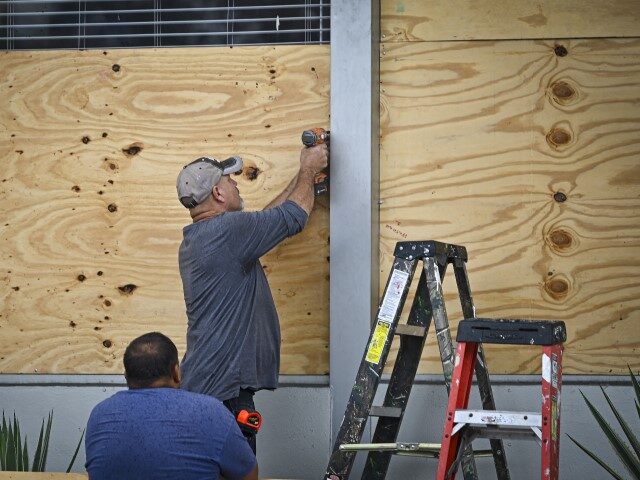 People board up a window in Tampa, Florida, on August 29, 2023 as the city prepares for Hu