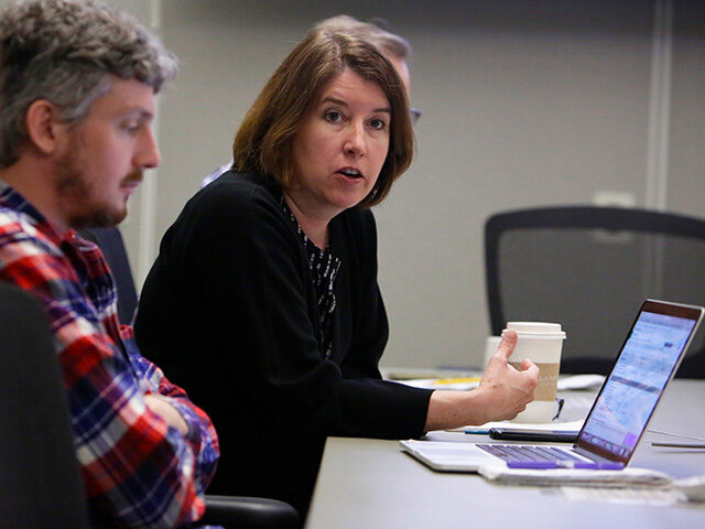 Mother Jones' editor in chief Clara Jeffery (right) speaks with staff during a news meetin