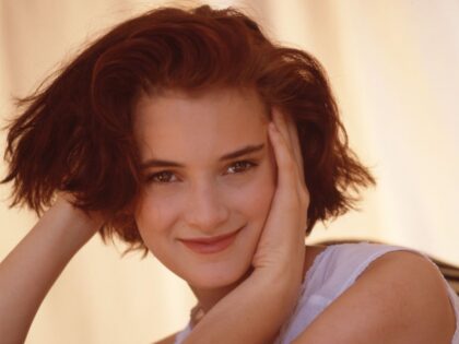 Actor Winona Ryder smiles with her hands in her hair in Los Angeles in 1989. (Photo by Bon