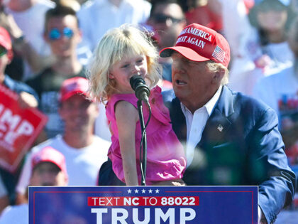 Former US President and Republican presidential candidate Donald Trump holds his granddaug