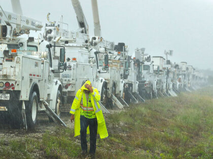 Charles Starling, a lineman with Team Fishel, is pelted with rain as he walks by a row of