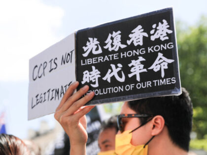 A pro-democracy activist holds placards saying liberate Hong...