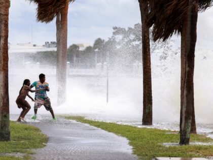 ST. PETERSBURG, FLORIDA - SEPTEMBER 26: People are splashed by churning surf from Tampa Ba