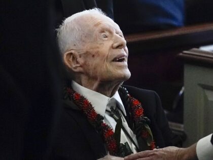 FILE - Former President Jimmy Carter greets attendees as he departs the funeral service fo