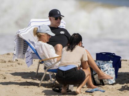 President Joe Biden and first lady Jill Biden, left, sit at the beach in Rehoboth Beach, D