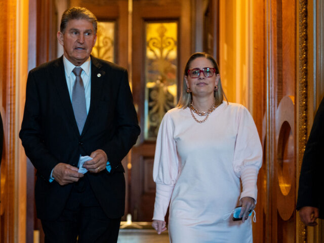 Sen. Joe Manchin (D-WV) leaves the Senate Chamber with Sen. Kyrsten Sinema (D-AZ) followin