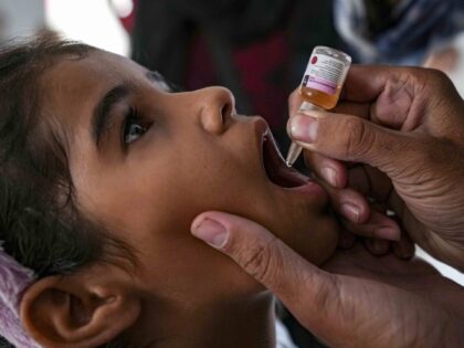 A health worker administers a polio vaccine to a child at a hospital in Deir al-Balah, cen