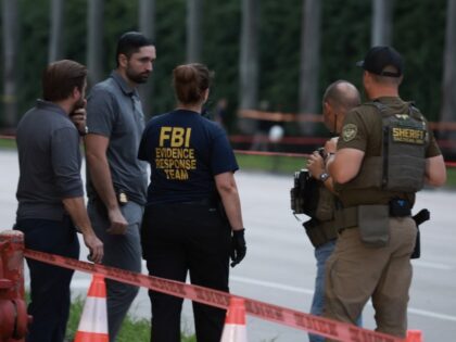 Law enforcement personnel investigate the area around Trump International Golf Club after