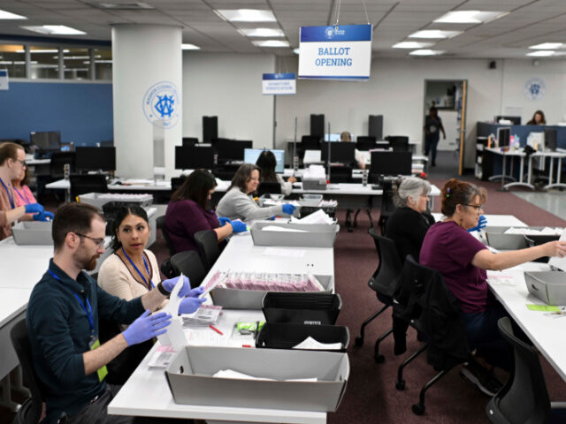 FILE - County employees open ballots in the mail ballot processing room at the Washoe Coun