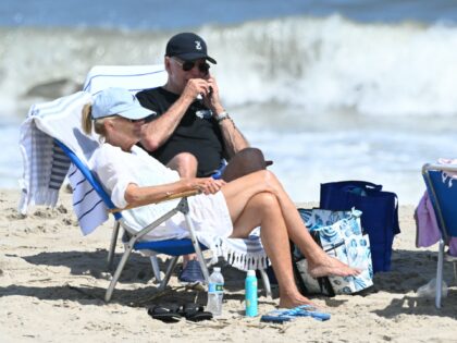 US President Joe Biden speaks on the phone as he and First Lady Jill Biden (L) spend time