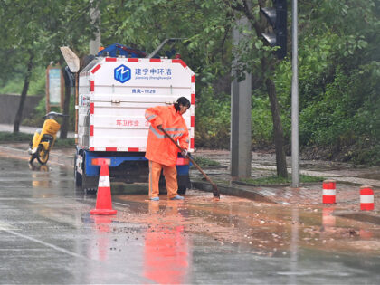 A sanitary worker cleans gravels on a street in Nanning, south China's Guangxi Zhuang Auto