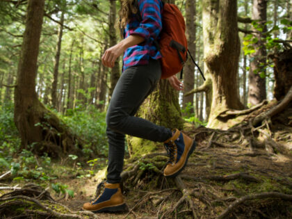 A woman hiking in a dense forest. - stock photo