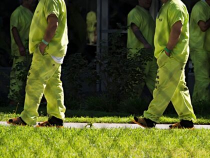 Men wearing neon-colored jail clothes signifying immigration detainees walk to pick up the