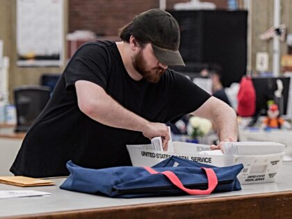 A staff member collects mail-in ballots during the primary race of the 2024 U.S. president