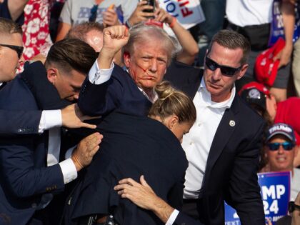 Republican candidate Donald Trump is seen with blood on his face surrounded by secret serv