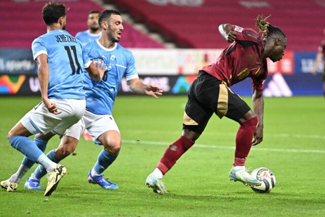 Belgium's Jeremy Doku dances away from Israel midfielders Sagiv Jehezkel (L) and Neta Lavi