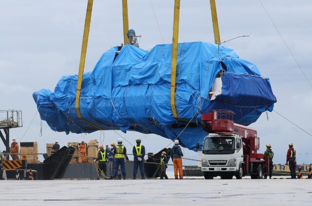 A crane lifts the salvaged Kazu I at Abashiri Port on June 1, 2022