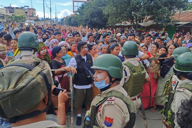 A crowd defies a round-the-clock curfew to protest in the Indian city of Imphal on Tuesday