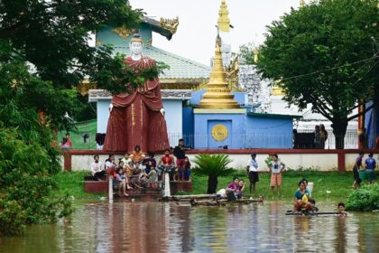 Flood-affected residents used bamboo rafts to paddle to the higher ground of a temple in T