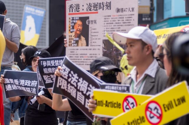 Hong Kong people living in Taiwan display placards and a poster showing detained pro-democ