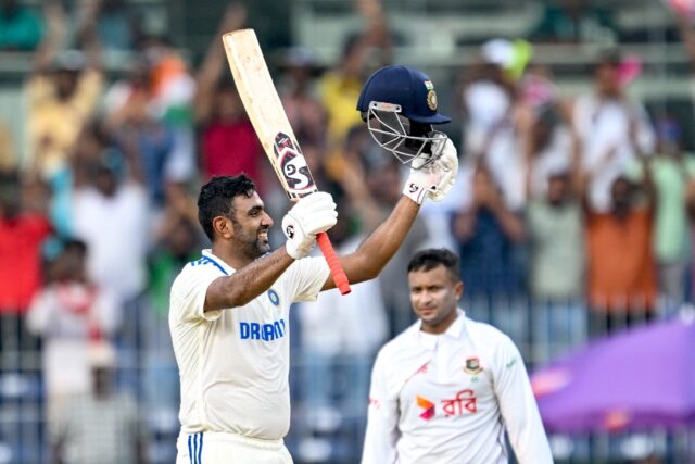 India's Ravichandran Ashwin (L) celebrates after scoring a century on day one of the first