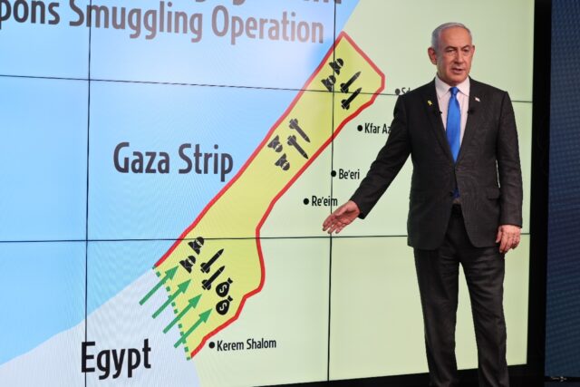 Israel's Prime Minister Benjamin Netanyahu stands in front of a map of the Gaza Strip as h