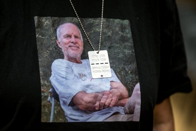 Israeli former hostage Aviva Siegel poses with a T-shirt showing her husband Keith Siegel,