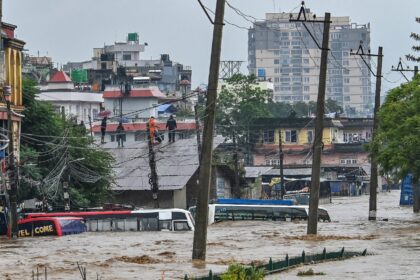 Kathmandu residents climb on the rooftops as their neighbourhood is submerged in flood wat