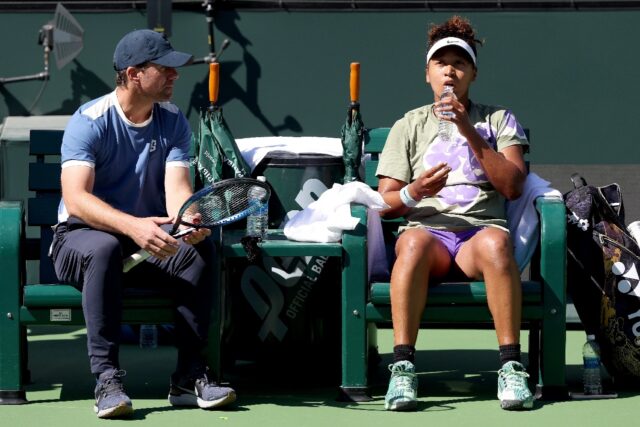 Former world number one Naomi Osaka of Japan confers with coach Wim Fissette while trainin