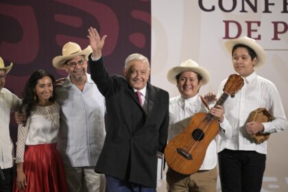 Outgoing Mexican President Andres Manuel Lopez Obrador waves next to members of the musica