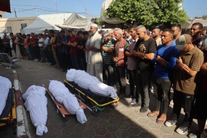 Palestinians mourn over the bodies of victims of Israeli bombardment in Deir el-Balah in c