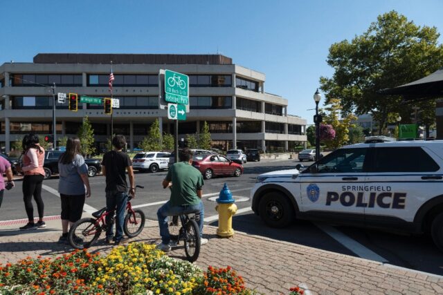 People watch as Springfield Police Department officers investigate the Springfield City Ha