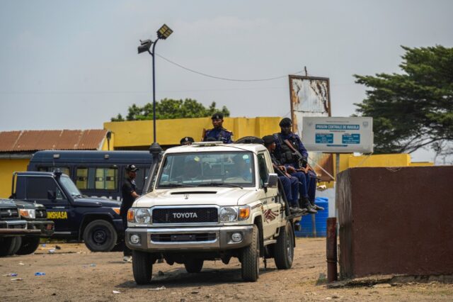 A police vehicle with officers leaves the Makala prison