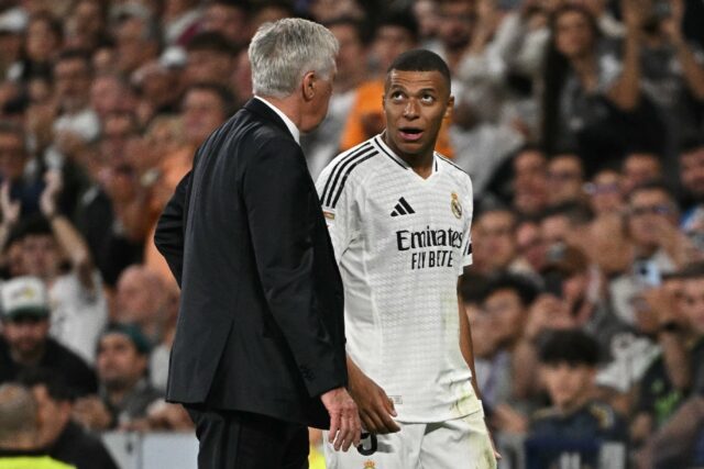 Real Madrid's French forward Kylian Mbappe with coach Carlo Ancelotti as he walked off aga