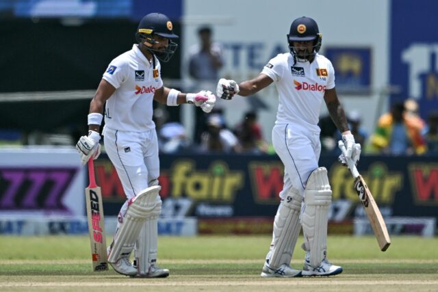 Sri Lankan batsmen Dinesh Chandimal (left) and Kamindu Mendis nump fists on the first day