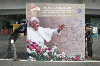 Workers install a billboard for the upcoming mass that will be led by Pope Francis in Jaka