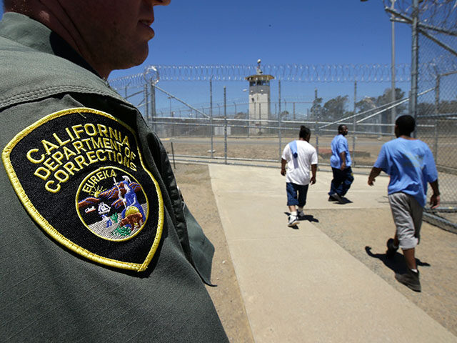 In this photo taken June 20, 2018, inmates pass a Correctional Officer as they leave an ex