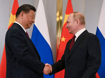 Russian President Vladimir Putin, right, and Chinese President Xi Jinping shake hands duri