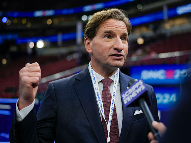 Rep. Dean Phillips, D-Minn., talks on the floor before the Democratic National Convention