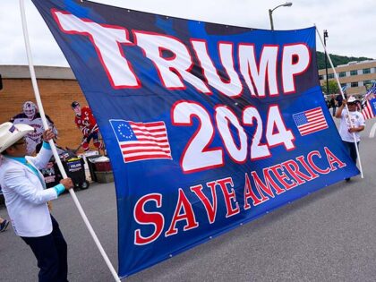 Supporters carry a large sign before a campaign event for Republican presidential nominee