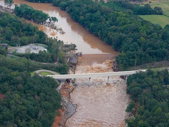 An aerial view of the Nolichucky Dam as water from the Nolichucky River flows over the top