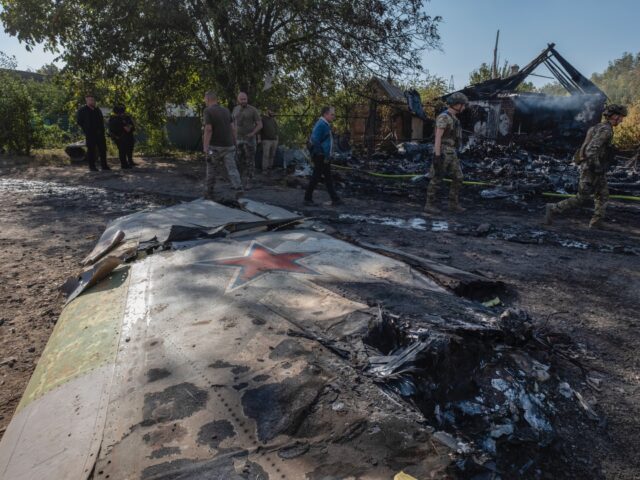 Ukrainian servicemen examine fragments of a Russian military plane that was shot down, on