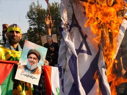 An Iranian demonstrator holds a poster of slain Hezbollah leader Hassan Nasrallah reading