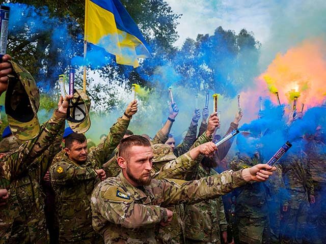 Ukrainian servicemen of the Azov brigade light flares during the funeral ceremony of falle