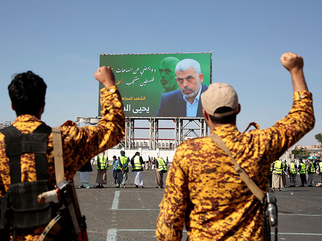 Yemeni soldiers shout slogans in front of a billboard showing Hamas leader Yahya Sinwar du