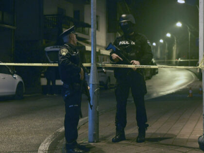 Bosnian police officer guard the local police station after a teenager broke and killed on