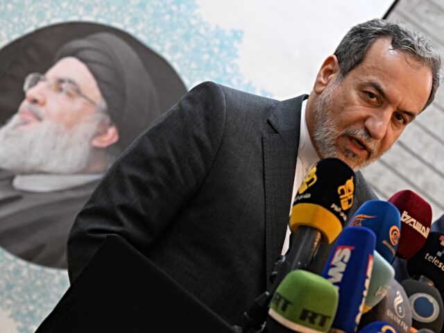 Iranian Foreign Minister Abbas Araghchi speaks to the press, in front of the portrait of s