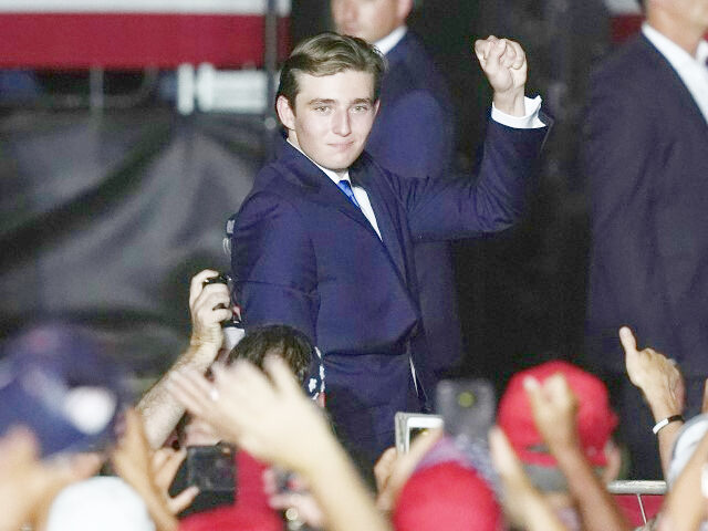 Barron Trump raises a clenched fist after he is introduced by his father, Republican presi