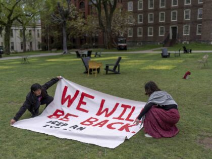 Demonstrators unfurl a banner on a lawn after an encampment protesting the Israel-Hamas wa