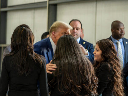 Former US President Republican presidential candidate Donald Trump (C) greets Gloria Guill